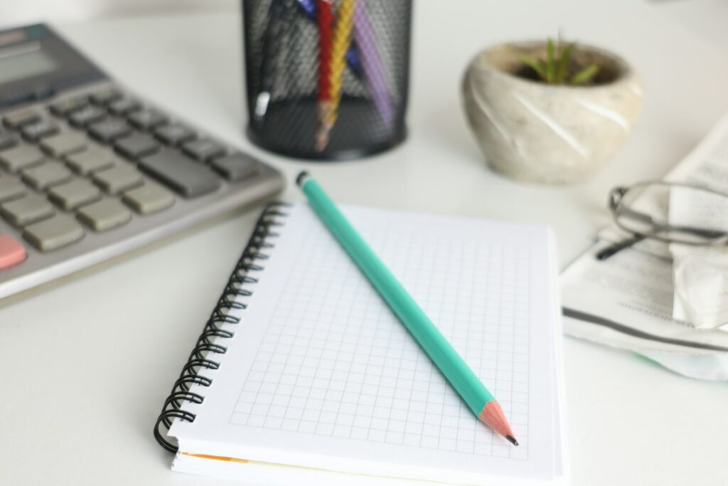 Bureau avec calculatrice, carnet et crayon pour préparer le budget énergie 2027